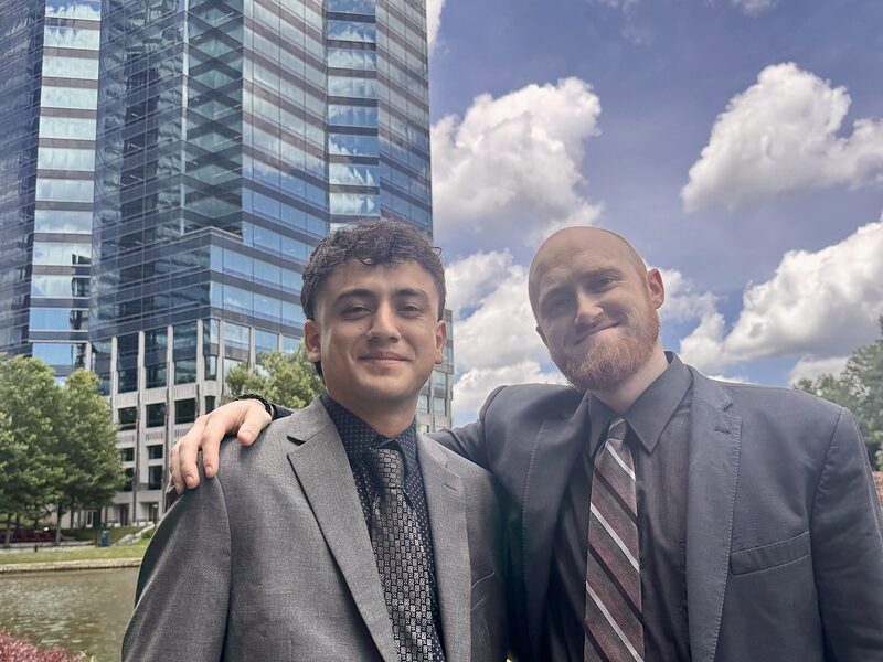 Two Palmora team members outside the Charlotte office by the water