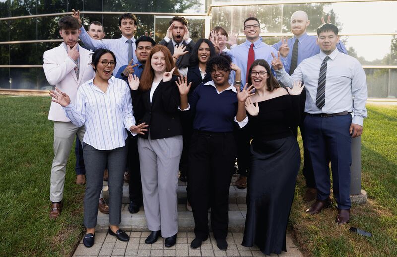 The Palmora team waving and laughing together outside their Charlotte office