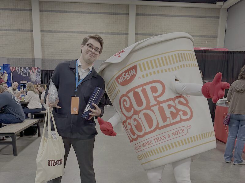 A Palmora team member with a brand mascot at a client activation event