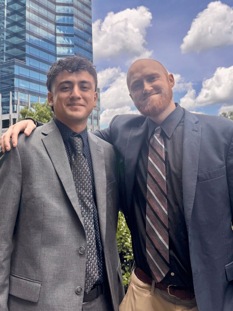 Two Palmora team members arm in arm outside Charlotte’s office towers